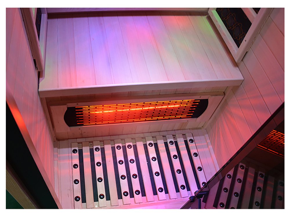 Interior of the Lumin One sauna with coloured lighting along the ceiling and a glowing infrared heater above the floor grille