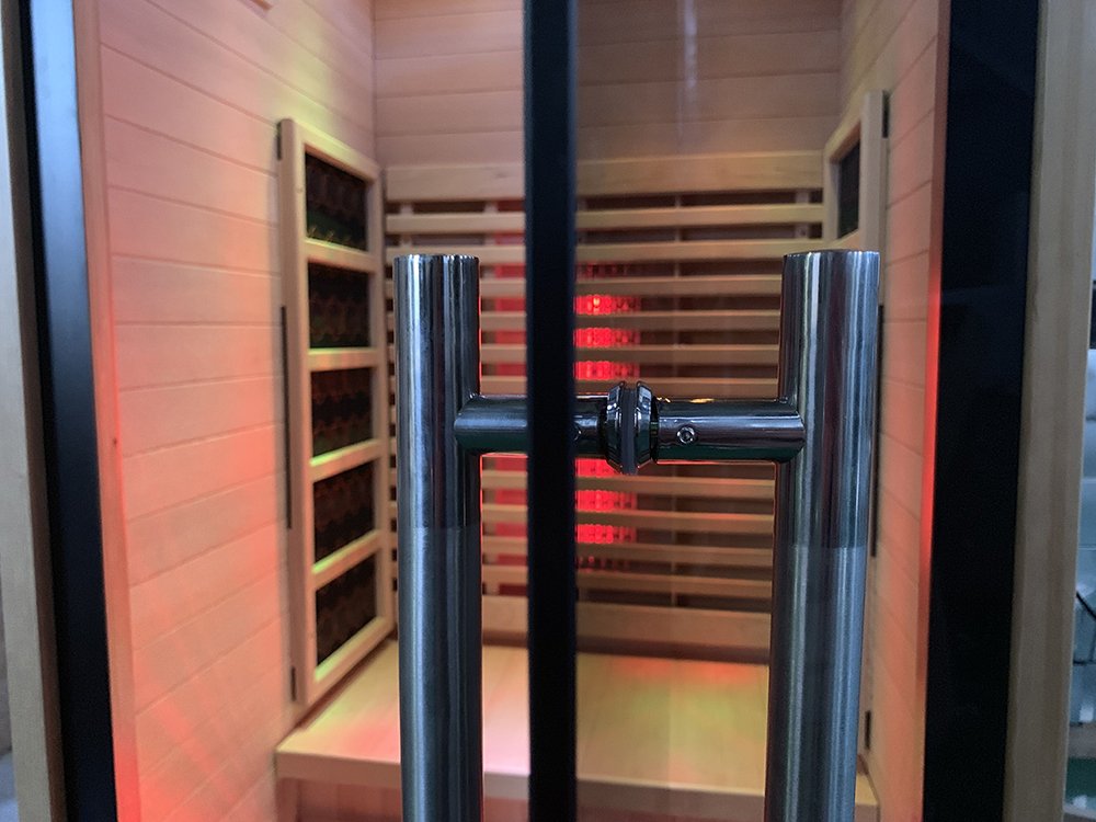 Close view of the Lumin One glass door handle with lit infrared emitters visible inside the cabin